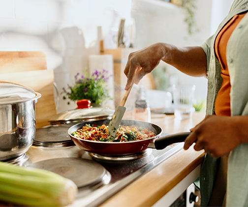 A photo of a woman cooking at the stovetop